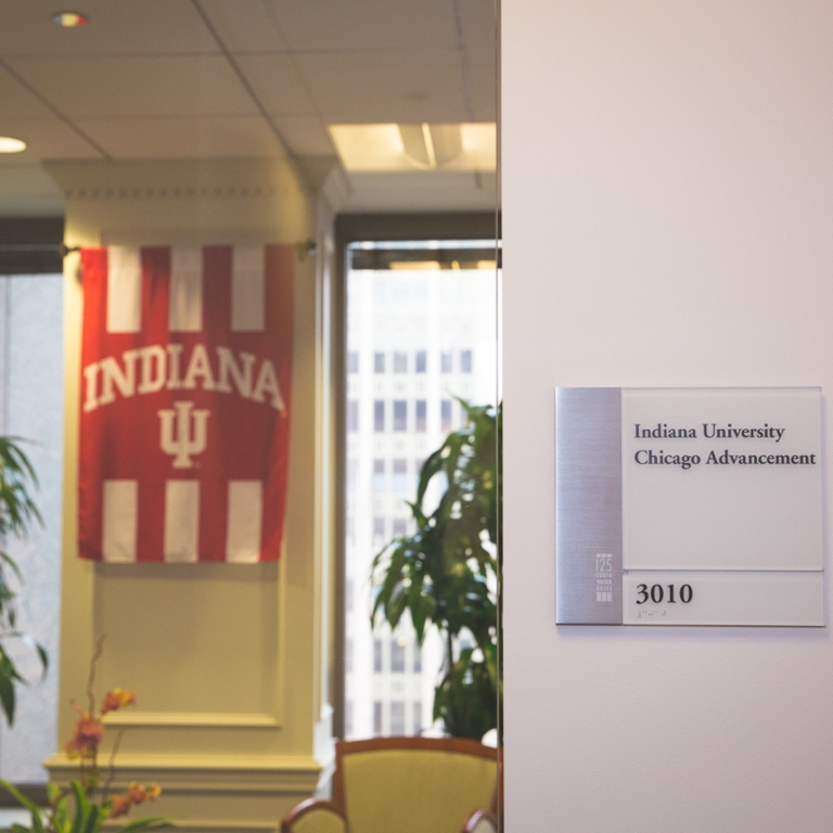 A group of wing chairs sits in front of a red and white Indiana University banner.